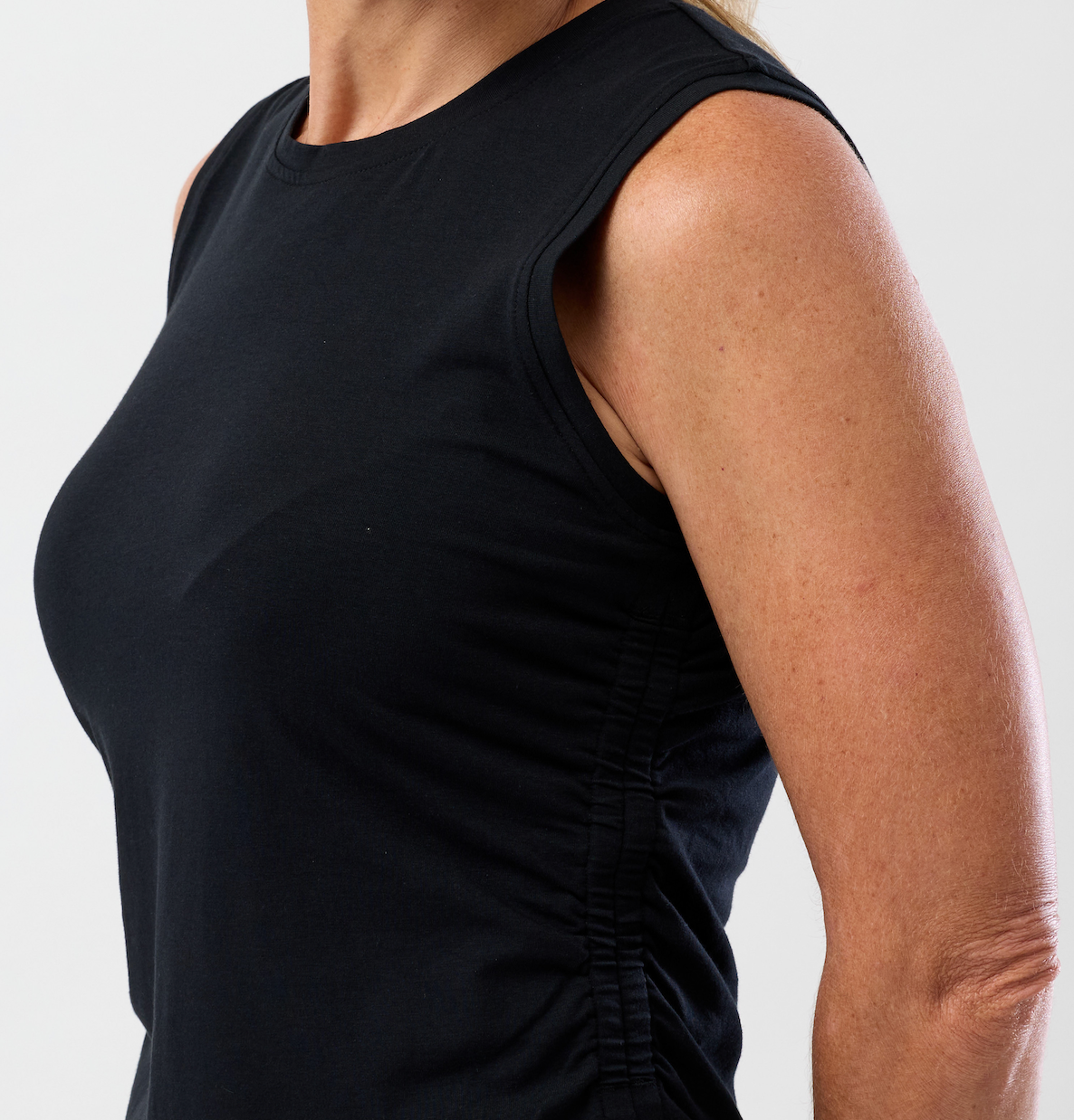 Close up view of the black stretchy cotton top worn by a women